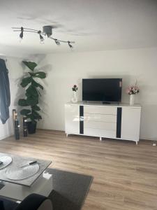 a living room with a tv on a white entertainment center at Beti Apartment in Nentershausen