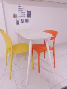 a white table with two chairs and a table with stickers on the wall at December homestay studio 002 in Ho Chi Minh City
