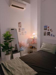 a bedroom with a bed and a plant and a mirror at December homestay studio 002 in Ho Chi Minh City