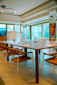 a dining room with tables and chairs and windows at Hotel Ulisse in Marina Romea