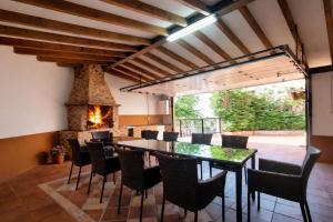 a dining room with a table and chairs and a fireplace at Llanes Casa con Terraza y Barbacoa – La Jorcada in Porrúa