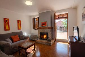a living room with a couch and a fireplace at Llanes Casa con Terraza y Barbacoa – La Jorcada in Porrúa