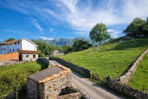 a road in a field next to a house at Llanes Casa con Terraza y Barbacoa – La Jorcada in Porrúa