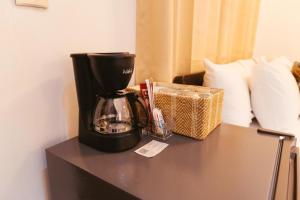 a coffee maker sitting on a table with a basket at Hotel Plaza Los Tucanes in Santiago +47 photos
