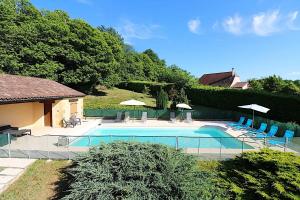 a large swimming pool with chairs and umbrellas at Pechboutier in Saint-Cyprien