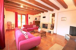 a living room with two pink couches and a tv at Pechboutier in Saint-Cyprien