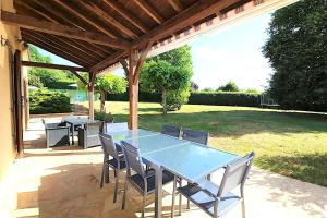 a table and chairs sitting under a pergola at Pechboutier in Saint-Cyprien