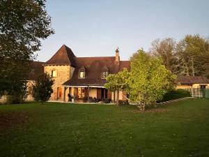 a large brick house with a green yard at Pechboutier in Saint-Cyprien