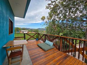 a wooden deck with a table and a bench at Chalés Refúgio da Sil in Cavalcante