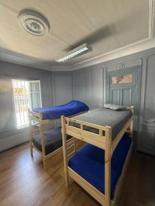 a bedroom with two bunk beds with blue sheets at Familyhostel in Santiago
