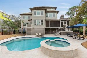 a house with a swimming pool in front of a house at 3 Surfsong in Kiawah Island