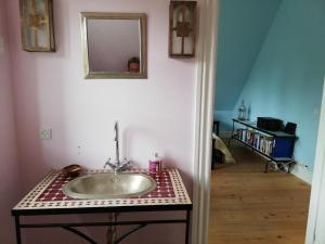 a bathroom with a sink and a mirror on a wall at Villa Ferie og Overnatning in Svendborg