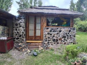 a small stone building with a window in a yard at B&B Dormis de montaña Memé in Potrerillos