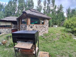 a stone building with a grill in a yard at B&B Dormis de montaña Memé in Potrerillos
