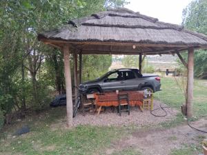 a table and chairs under a gazebo with a car at B&B Dormis de montaña Memé in Potrerillos
