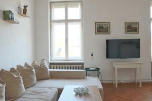 a living room with a white couch and a tv at Apartment Hans - Wohnen im Herzen des Drautales in Feistritz an der Drau +7 photos