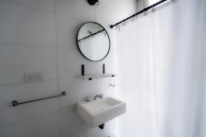a white bathroom with a sink and a mirror at Añelo Nuevo Housing in Añelo +30 photos