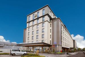 a white van parked in front of a building at Limak Skopje Luxury Hotel in Skopje