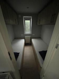 a small room with two beds and a window at Chalet Pallegarste 153 in Mariënberg +12 photos