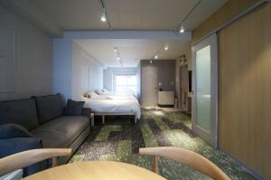 a living room with a couch and a bed at Hotel Sakura Riverside in Nagoya