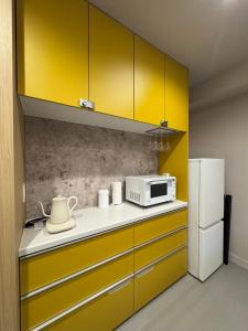 a kitchen with yellow cabinets and a microwave at Hotel Sakura Riverside in Nagoya