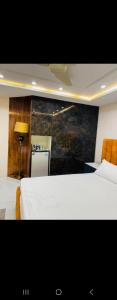 a bedroom with two beds and a table and a lamp at Regency Crown Hotel in Faisalabad