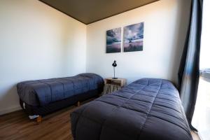a bedroom with two beds and a window at Añelo Nuevo Housing in Añelo