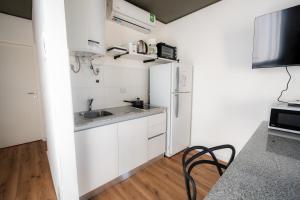a white kitchen with a sink and a refrigerator at Añelo Nuevo Housing in Añelo