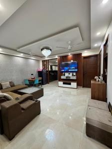 a large living room with couches and a flat screen tv at 3BHK Independent Floor in New Delhi