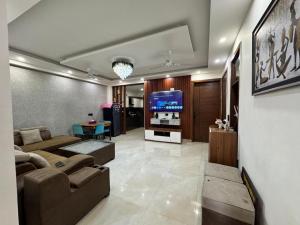 a living room with a couch and a television at 3BHK Independent Floor in New Delhi