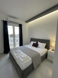 a bedroom with a large bed and a window at Mediterranean Port Suite in Ágios Rókkos