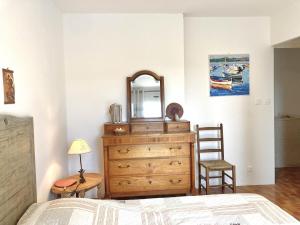 a bedroom with a dresser with a mirror and a chair at Villa hortus mariae in Le Thoronet