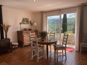 a dining room with a table and chairs and a window at Villa hortus mariae in Le Thoronet