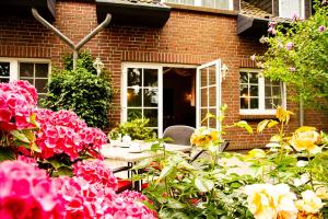 a table with flowers in front of a brick house at Pension Seeluft in Ahrenshoop