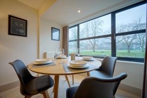 a dining room with a table and chairs and a large window at Riverside Park 1 in Keswick