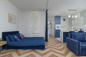 a living room with a blue bed and a kitchen at Cozy Attic in Marki