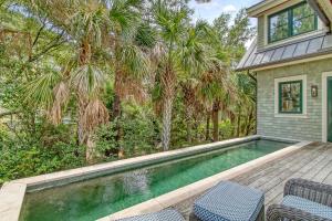 a swimming pool with two chairs and a house at 119 Halona Ln in Kiawah Island