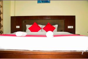 a bedroom with a bed with red pillows at Hotel tridev in Manāli +4 photos