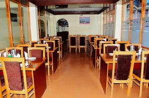 a dining room with wooden tables and chairs at Hotel tridev in Manāli