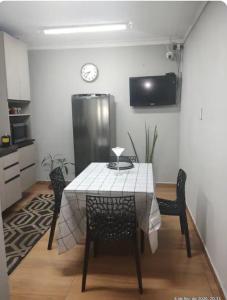 a table and chairs in a kitchen with a clock on the wall at Casa Magalhães Hospedaria in Extrema