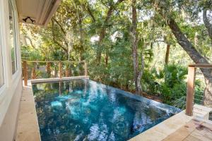 a swimming pool in the middle of a house with trees at 217 Glen Abbey in Kiawah Island