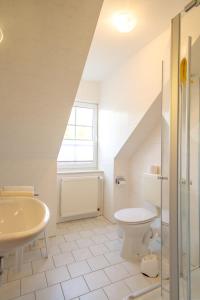 a white bathroom with a sink and a toilet at Pension Seeluft in Ahrenshoop