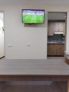 a living room with a television on a wall at Vadamar Apartment in Sisian +7 photos