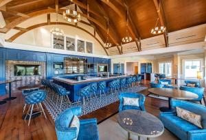 a lobby with a bar with blue chairs and tables at 2455 The Bent Twig in Seabrook Island