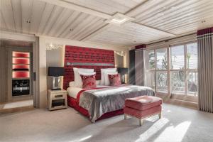 a bedroom with a large bed with a red headboard at Hotel Le K2 Altitude in Courchevel