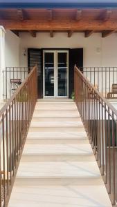 a wooden bridge leading to a house with a door at La Bianca Dimora B&B in Gioia del Colle