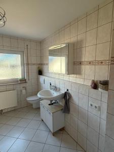 a bathroom with a sink and a toilet and a mirror at Ferienwohnung in Staufenberg- Treis in Staufenberg +8 photos