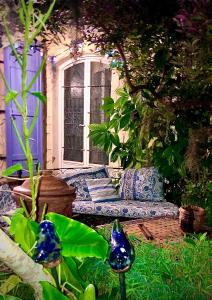 a garden with a blue couch in front of a window at La Porte Bleue le grenier des Anges in Saint-Pierre