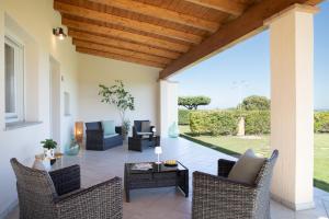a patio with wicker chairs and a table at Sole d'Estate Agriresidence in Costa Rei
