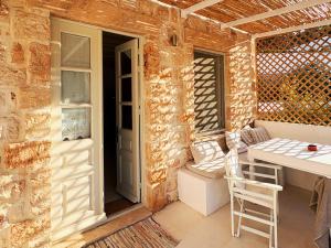 a patio with a table and chairs and a door at Agnanti Beach House in Patmos +42 photos